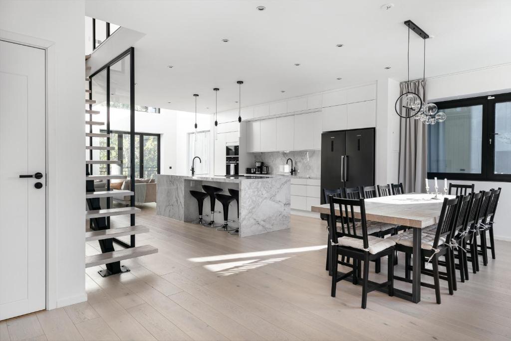 a kitchen and dining room with a table and chairs at Stylish and spacious family home in Stockholm
