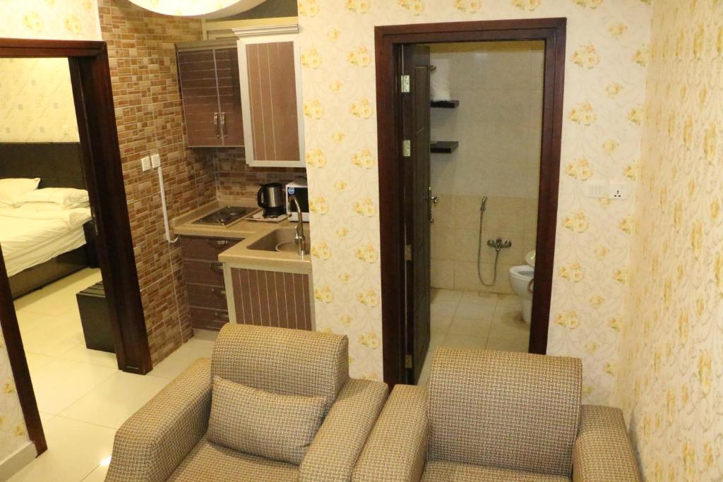 uma pequena cozinha com 2 cadeiras e uma casa de banho em Oroub El Forssan em Buraydah