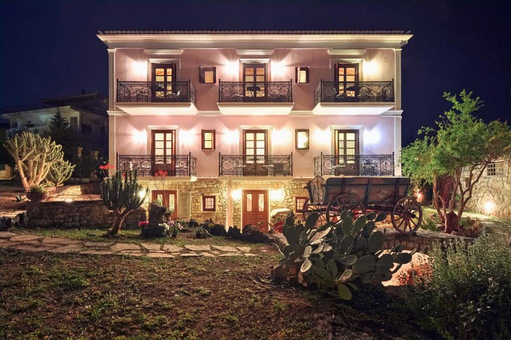 a large white house at night with lights at Archontiko Art Hotel in Galaxidi