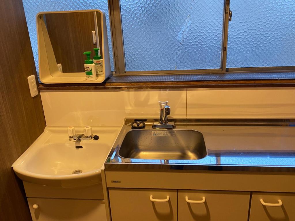 a kitchen with a sink and a mirror and a sink at guest house goose - Vacation STAY 23621v in Hirosaki