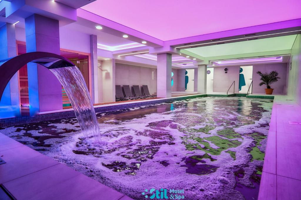 a indoor pool with a water fountain in a building at Stil Motel & Spa in Tăşnad