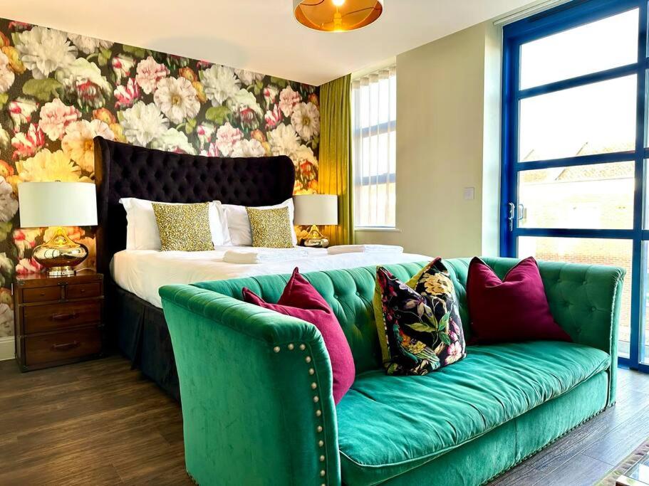 a bedroom with a green couch and a bed at Chic Modern Apartment Suite - Free Parking & WiFi! - 1 Minute walk to Poole Quay - Great Location - Free Parking - Fast WiFi - Smart TV - Newly decorated - sleeps up to 2! Close to Poole & Bournemouth & Sandbanks in Poole