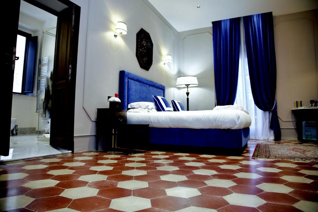 a bedroom with a blue bed and blue curtains at Palazzo Papa Gregorio XVI in Tivoli