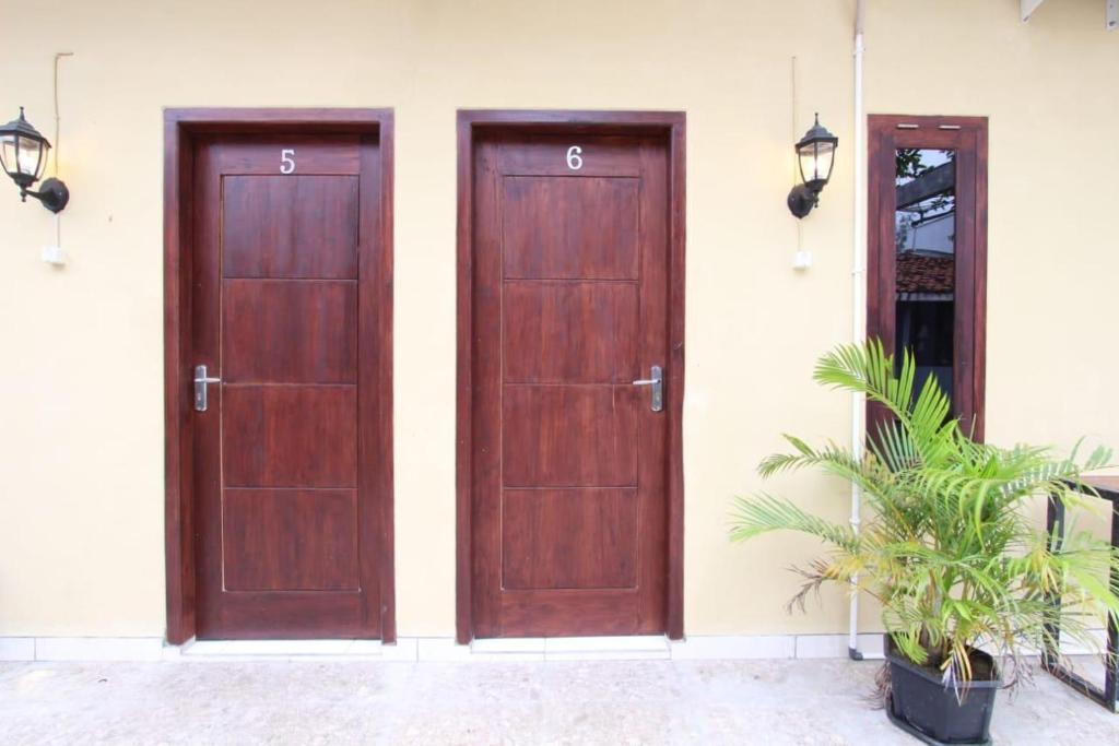 zwei Holztüren an der Seite eines Gebäudes in der Unterkunft Jaka Homestay in Rembang
