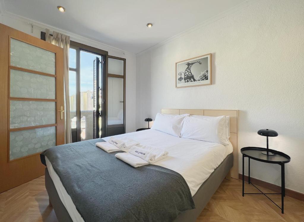 a bedroom with a large bed with white sheets and pillows at Stay U-nique Apartments Calabria in Barcelona