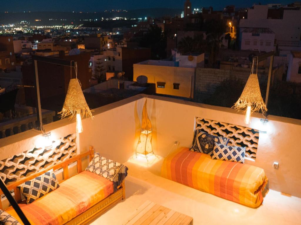 a balcony with two beds and a view of a city at Santacruz Hostel in Tamraght Ouzdar