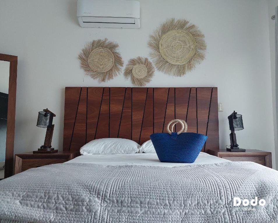 a bedroom with a bed with a blue pillow on it at Dodo Plaza Machado in Mazatlán