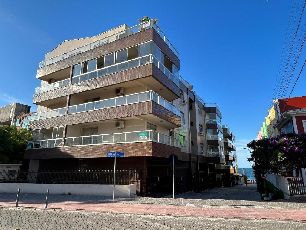 wysoki budynek z balkonami od strony ulicy w obiekcie Ed. Solar de Bombinhas w mieście Bombinhas