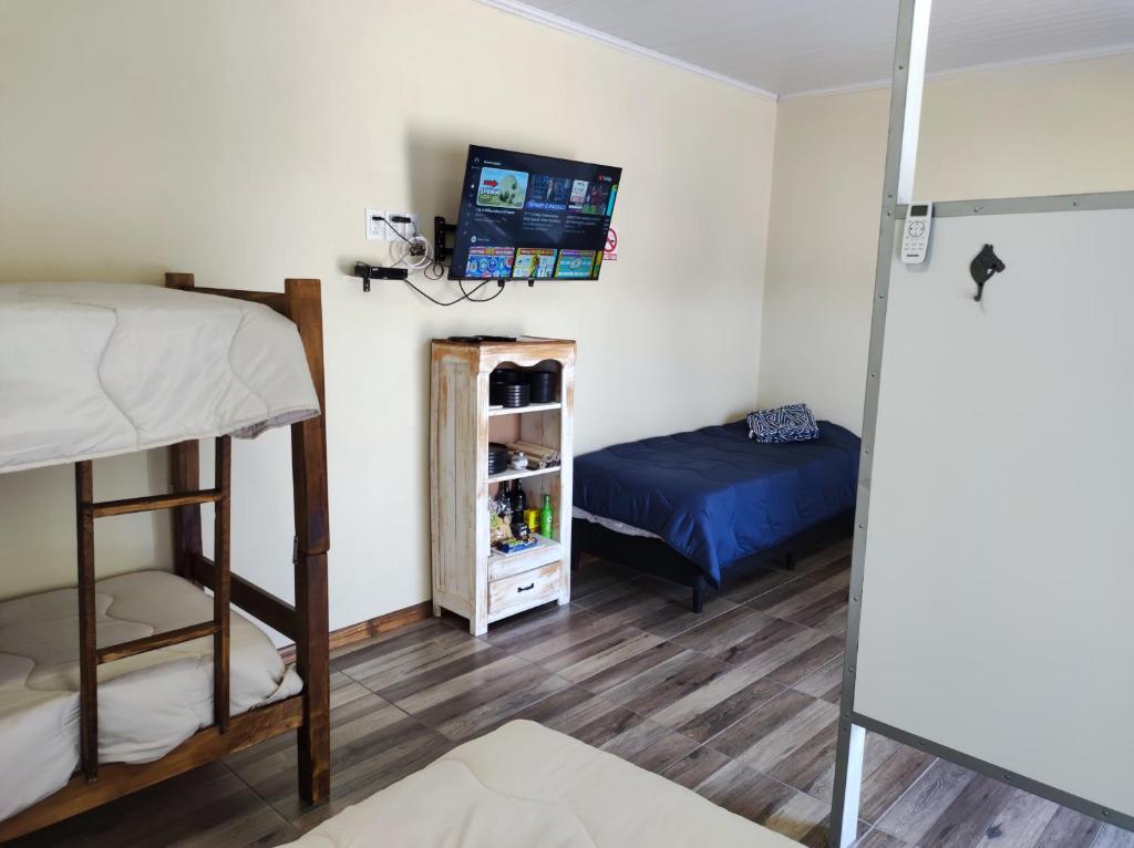 特立尼達的住宿－Casita de Piedra 10，一间卧室配有一张双层床和一张床,配有电视