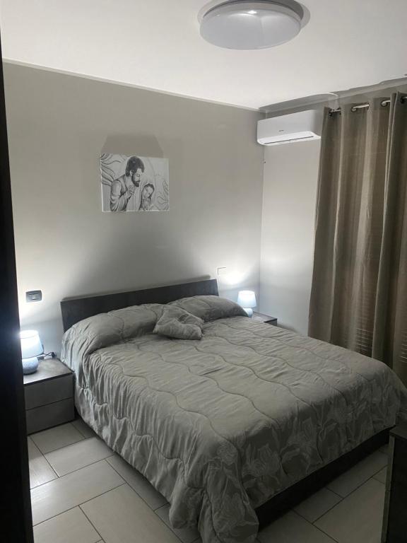 1 dormitorio con 1 cama y una foto en la pared en Casa Giuly, en Nápoles