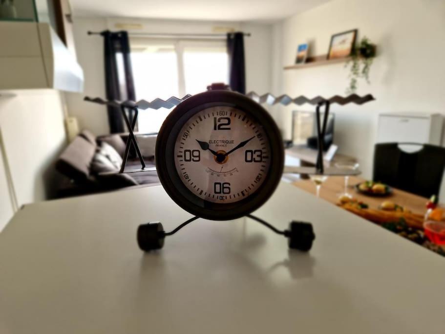 - une horloge assise sur une table dans le salon dans l'établissement L'ESCALE, proche Suisse, parking, à Hésingue