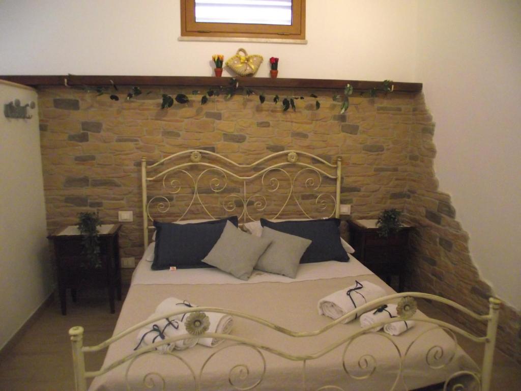 a bed in a room with a brick wall at CASETTA_JOLANDA in Trapani