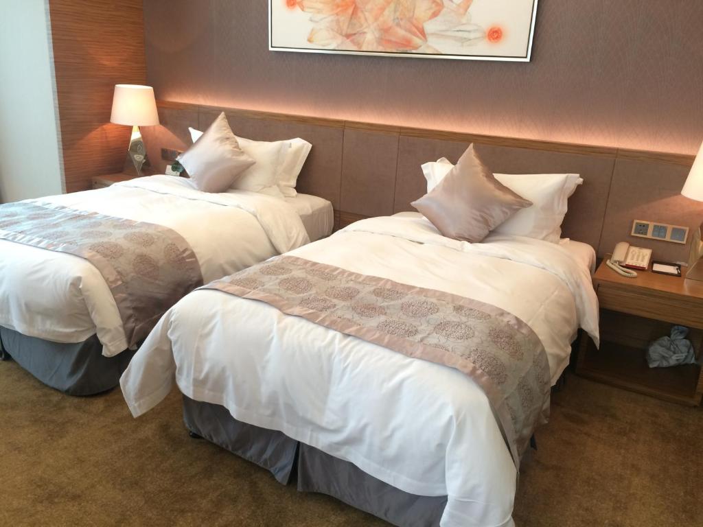Postel nebo postele na pokoji v ubytování Shenzhen Baoan PLUS Gems Cube Hotel