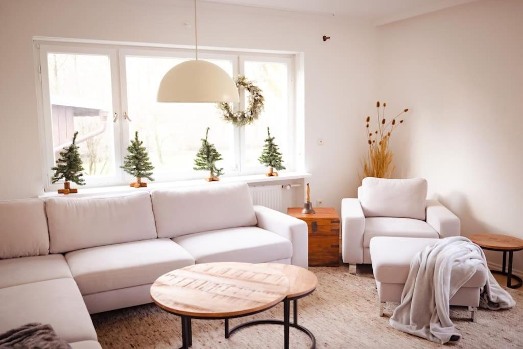 ein Wohnzimmer mit einem weißen Sofa und einem Tisch in der Unterkunft Gemütliches Haus mit Holzofen & Garten in Landshut