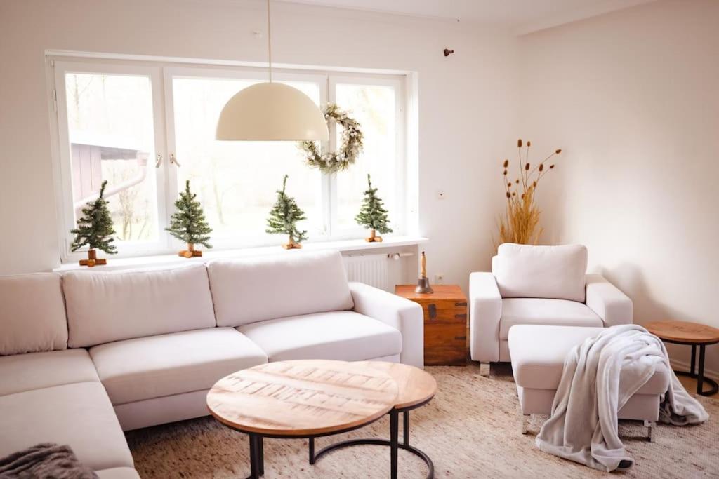 a living room with a white couch and a table at Gemütliches Haus mit Holzofen & Garten in Landshut