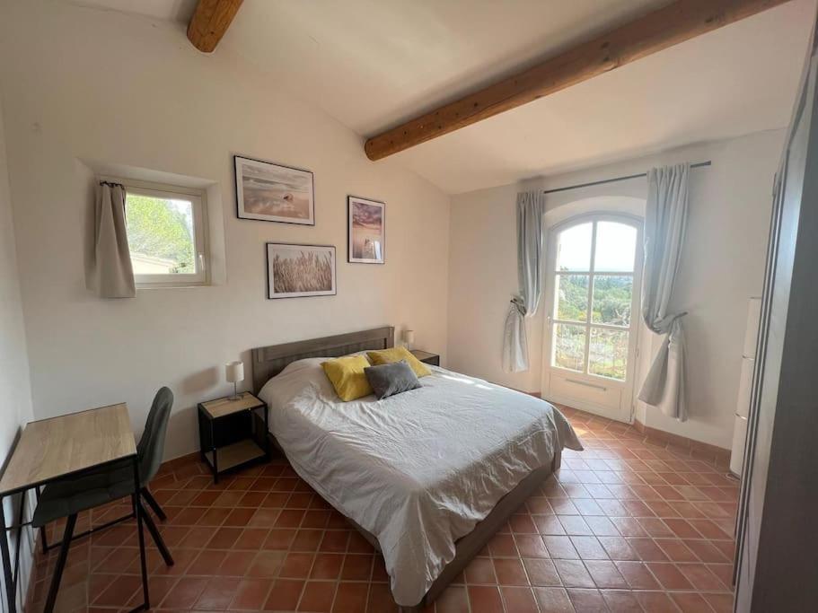 sypialnia z łóżkiem, biurkiem i oknem w obiekcie Grande villa avec piscine et vue panoramique w mieście Saumane-de-Vaucluse