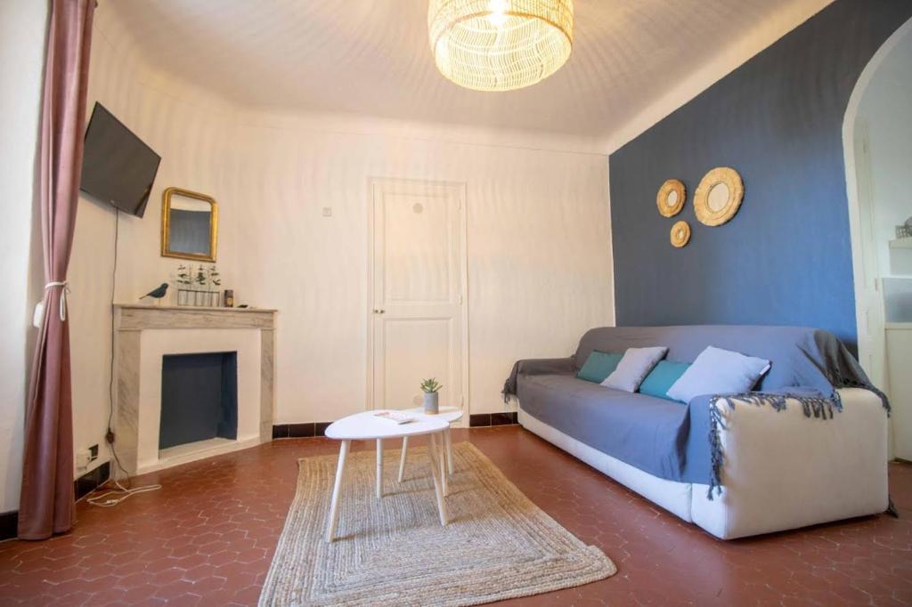 a living room with a blue couch and a fireplace at SUITE CHARABOIS in Saint-Raphaël
