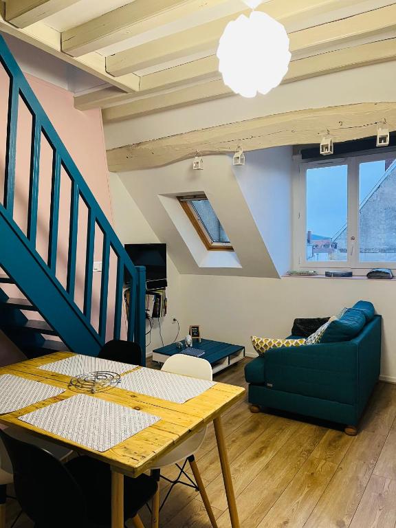 un salon avec un canapé bleu et une table dans l'établissement Gite la Bancloque, à Compiègne