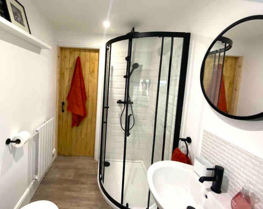 a bathroom with a shower and a sink and a mirror at The Little House in Cotherstone