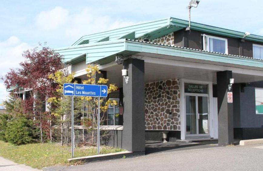 un panneau bleu devant un bâtiment dans l'établissement Hôtel Les Mouettes, à Sept-Îles