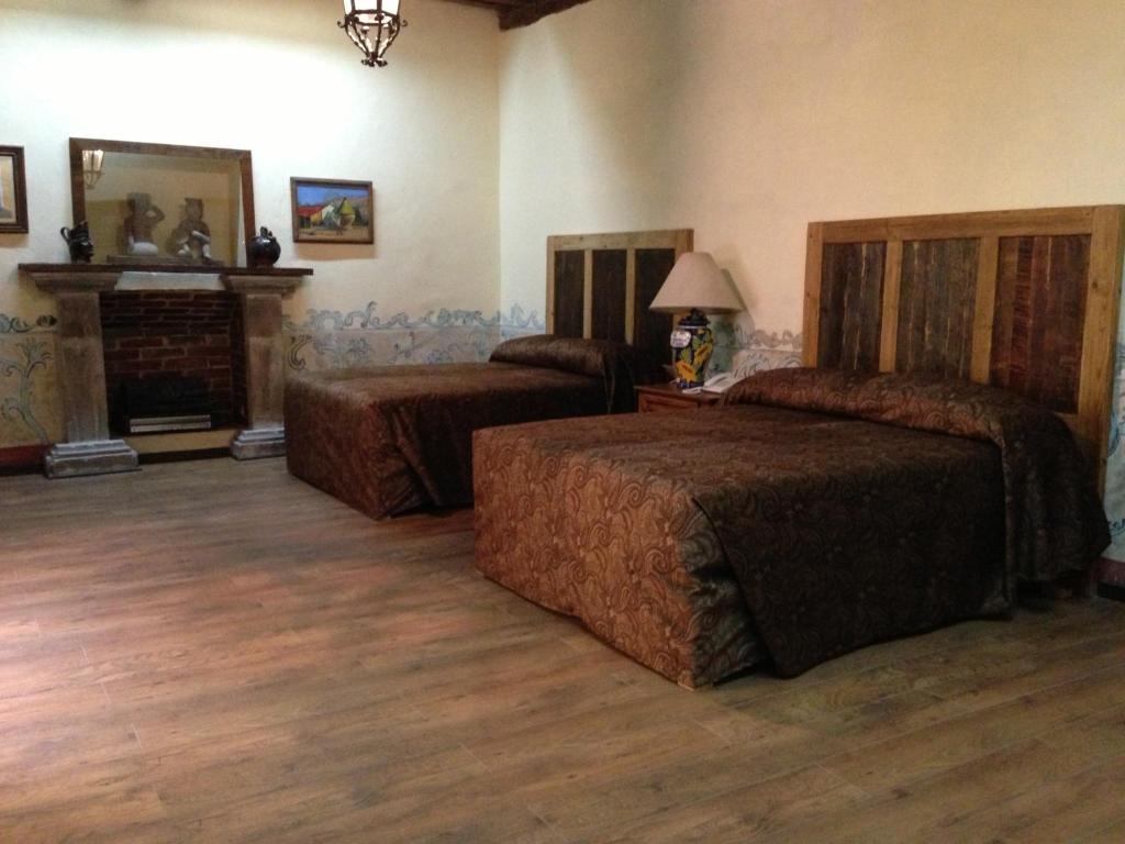 a bedroom with two beds and a fireplace at Hotel Travel in Puebla