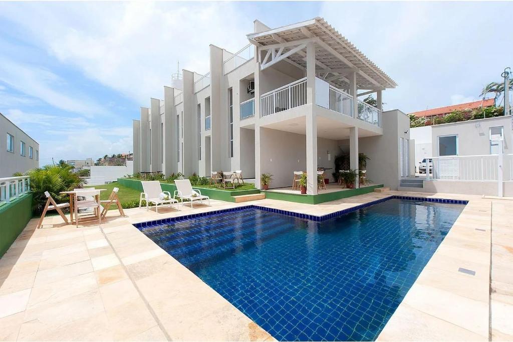 uma casa com piscina ao lado de um edifício em Beach Townhouses #C8 - Aconchego por Carpediem em Aquiraz