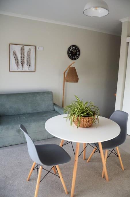 a living room with a table and chairs and a couch at Cantinho do Pópulo - Beach House in Ponta Delgada