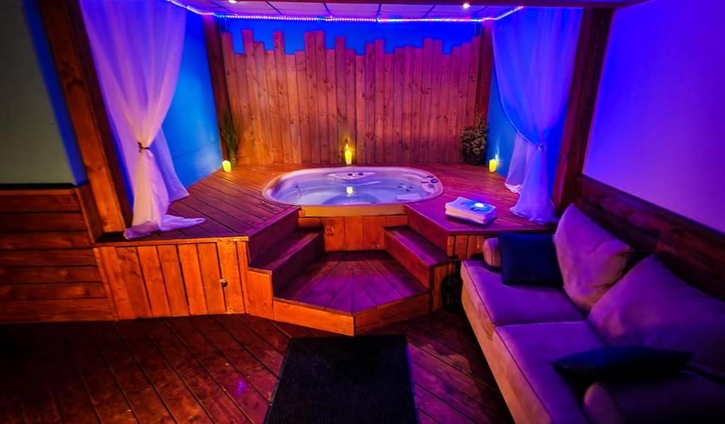 a sauna with a jacuzzi tub with purple lighting at Petit studio très intime, avec spa intérieur au coeur de Shawinigan in Shawinigan