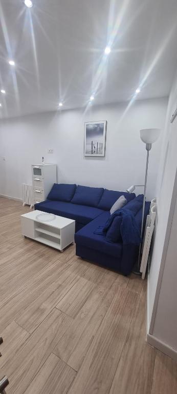 uma sala de estar com um sofá azul num quarto em Apartamentos Les Texuques II em Nueva de Llanes