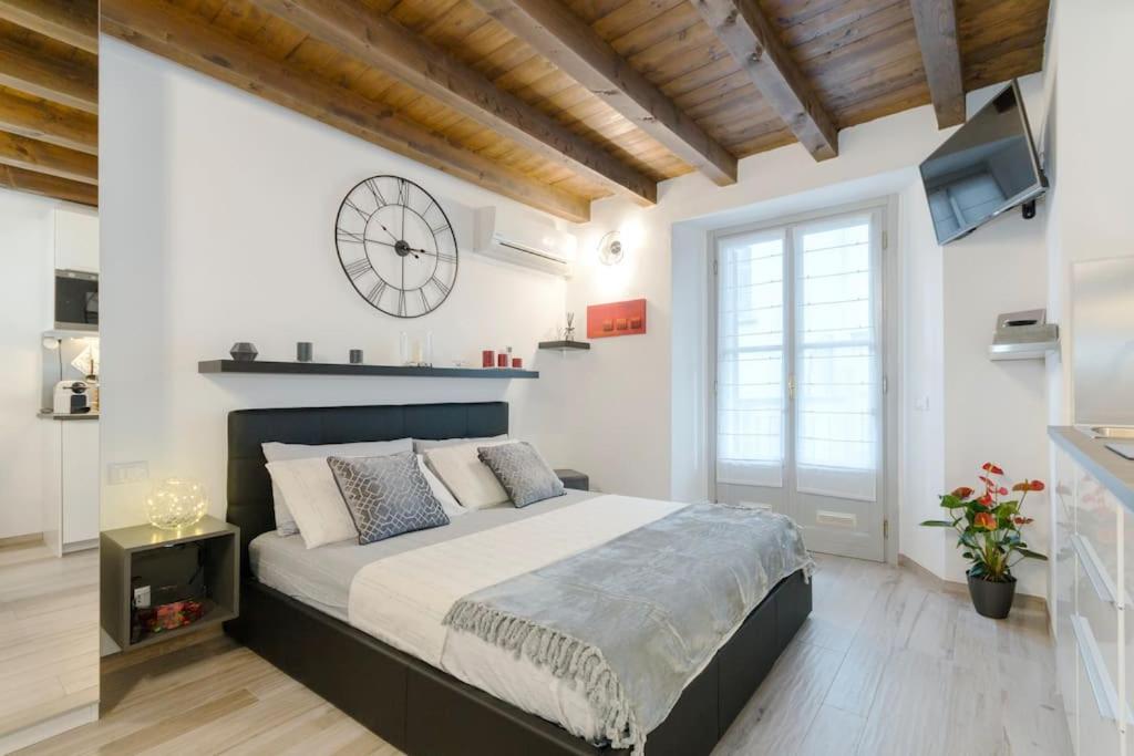 una camera con un grande letto e un orologio a muro di Antico Loft Como a Como