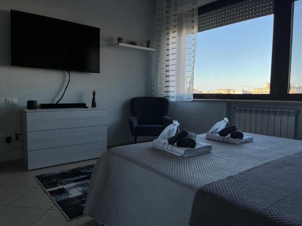 a bedroom with a bed and a chair and a television at casa Manthone - LuxRental Apartments in Pescara