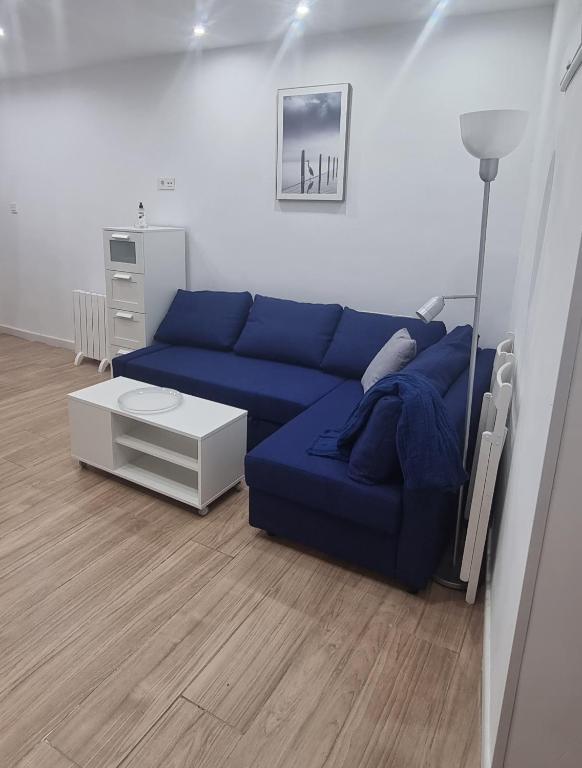 a living room with a blue couch and a table at Apartamentos Les Texuques II in Nueva de Llanes