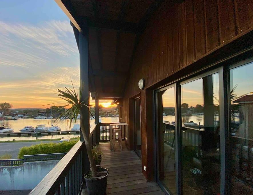 une terrasse couverte d'une maison avec vue sur l'eau dans l'établissement Appartement 50m2 - 1ère Ligne Vue Port de La Teste, à La Teste-de-Buch