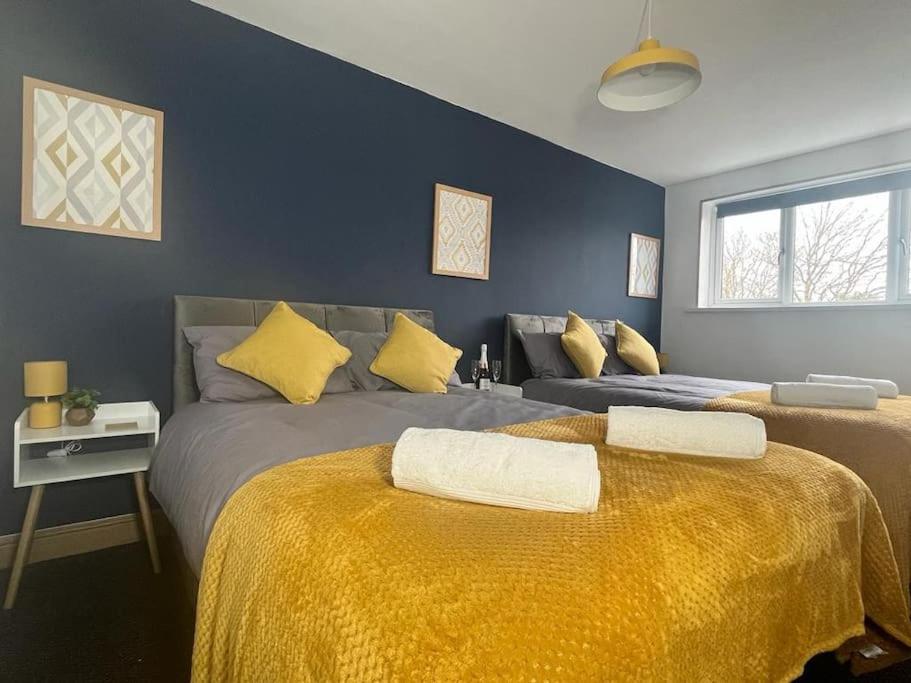 a bedroom with two beds with yellow sheets at Stylish 2 bed apartment. in Birmingham