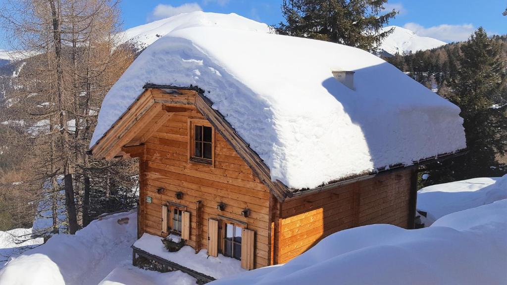a log cabin with a snow covered roof at Chalet Bergliebe Turrach in Turracher Hohe
