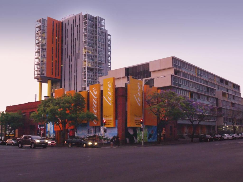 una strada cittadina con auto parcheggiate di fronte a un edificio di iStay Precinct Adelaide a Adelaide
