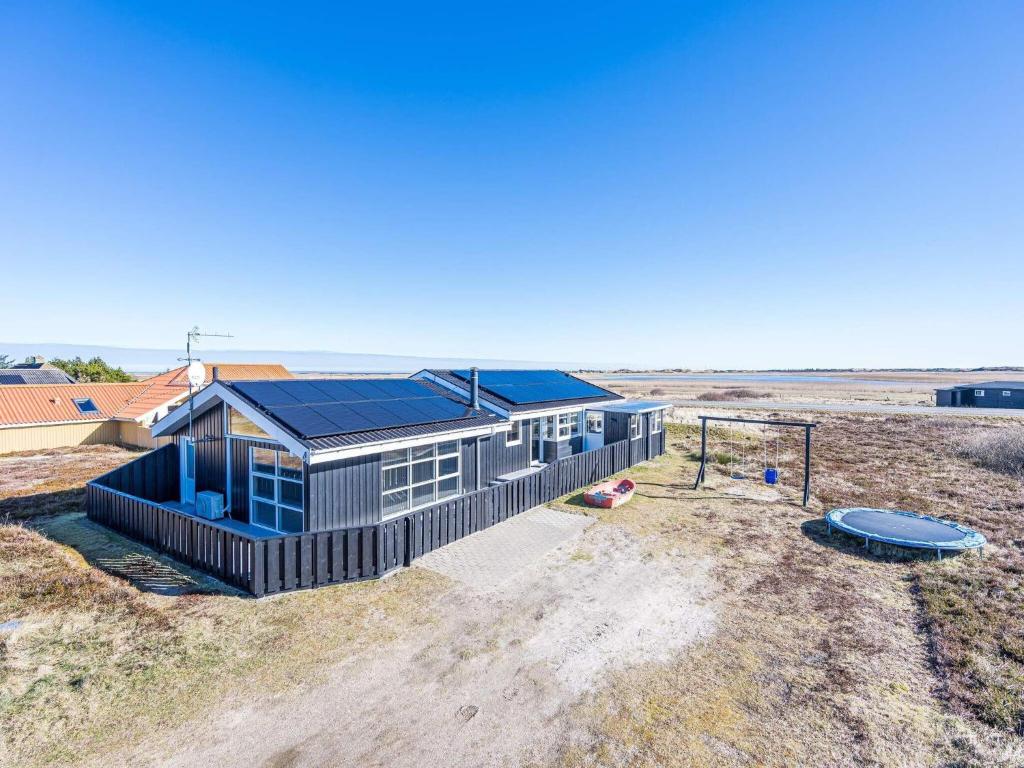 uma imagem de uma casa com painéis solares em 6 person holiday home on a holiday park in Hvide Sande em Bjerregård