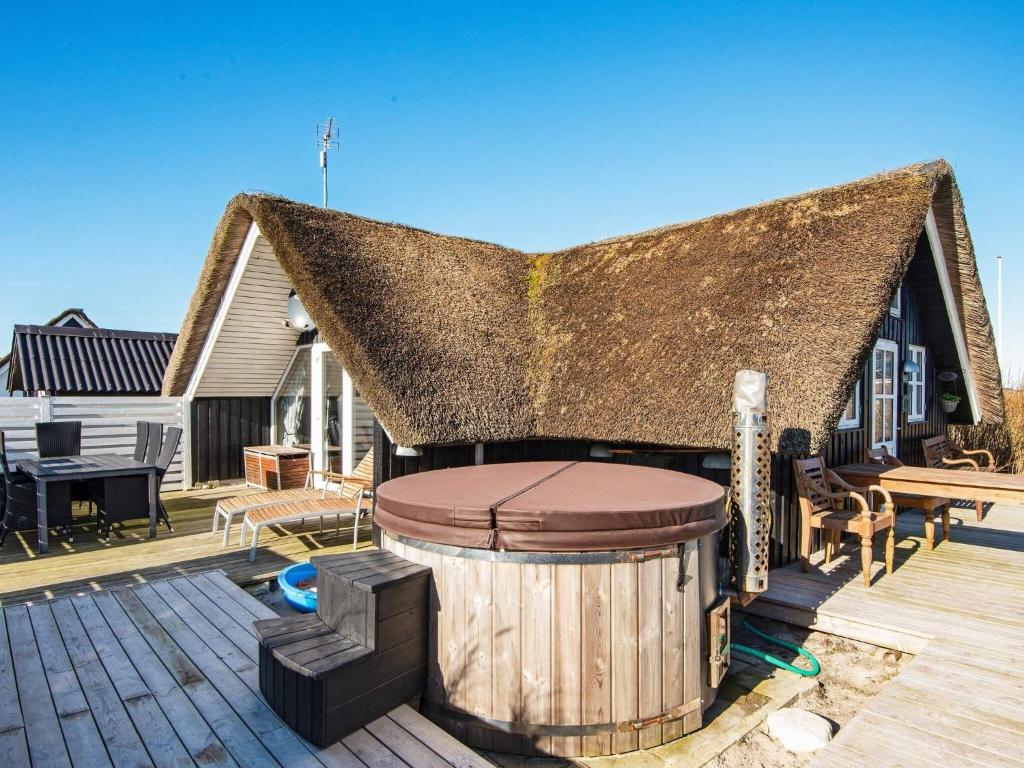 a house with a thatched roof with a hot tub at Holiday home Harboøre XLII in Harboør