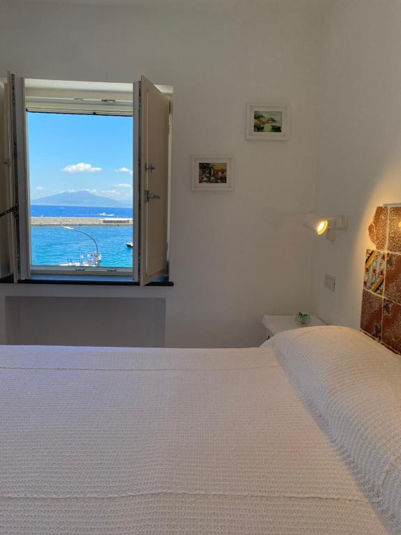 Un dormitorio con una cama grande y una ventana en La Baia di Napoli, en Capri