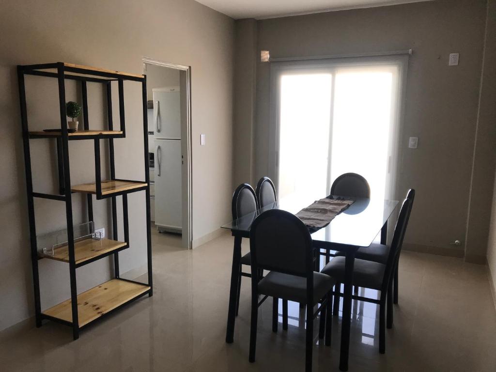 a dining room with a table and chairs and a window at Depto en Tucumán in San Miguel de Tucumán