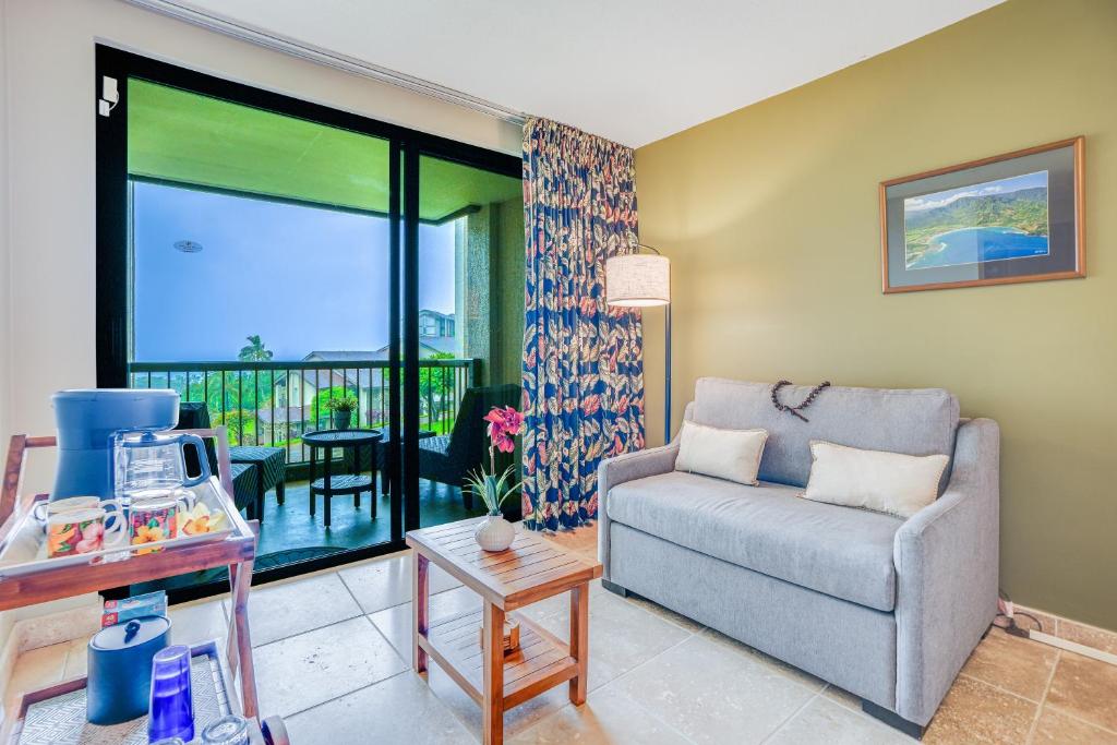 sala de estar con sofá y balcón en Hanalei Bay Resort 7204, en Princeville