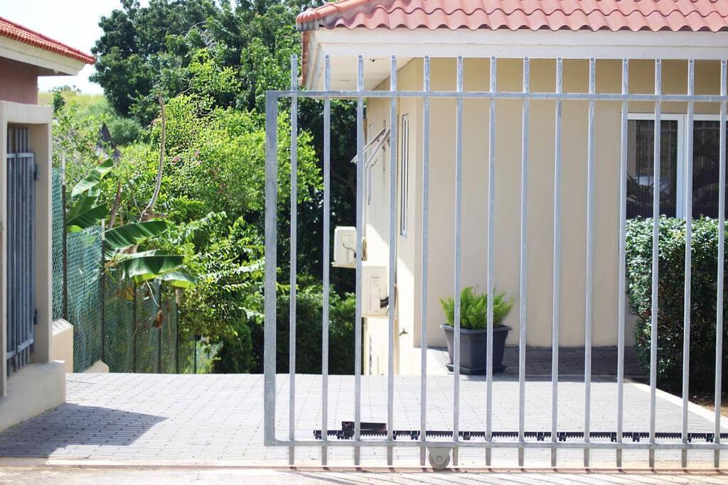 un cancello di metallo sul lato di una casa di Gamay Souterrain Apartment, near beach in Curaçao a Jan Thiel