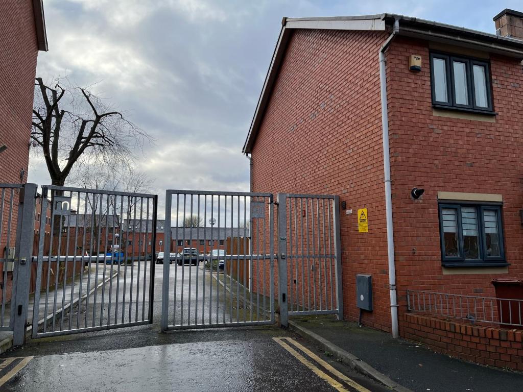 a metal gate in front of a brick building at Entire house with parking in Manchester
