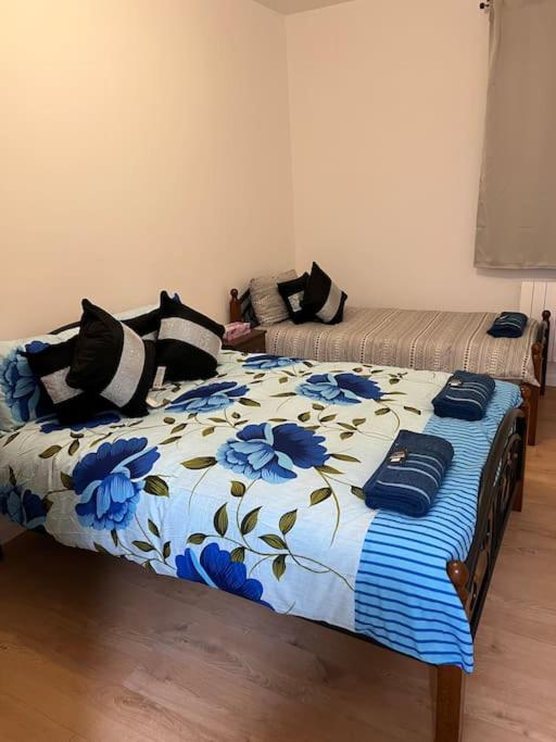 a bedroom with a bed with a blue and white comforter at 004- Brand new 1 bedroom apartment F1 in Ealing