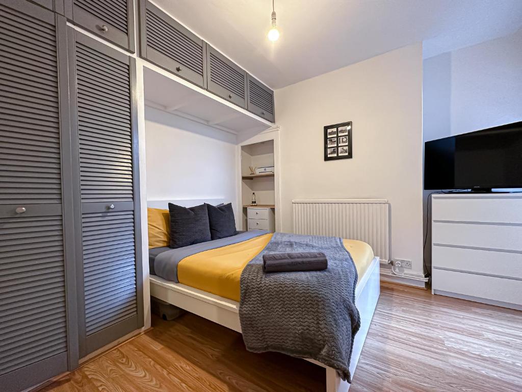 a bedroom with a bed and a flat screen tv at Liberty Street in London