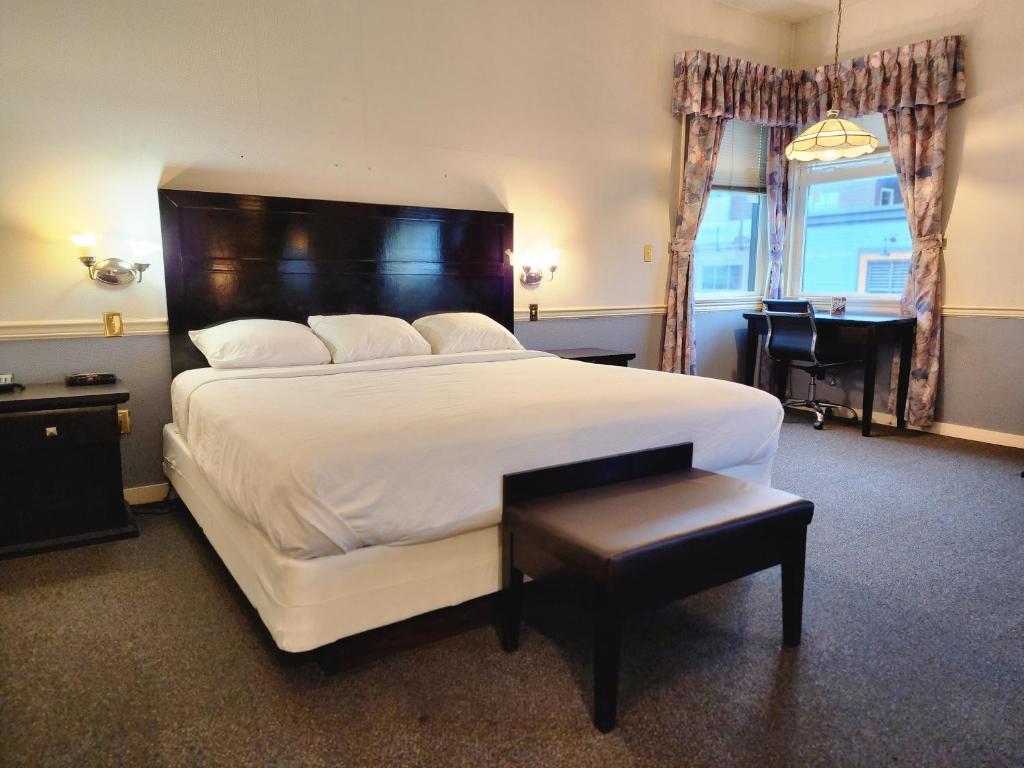 a bedroom with a large white bed and a desk at The Steveston Cafe & Hotel in Richmond