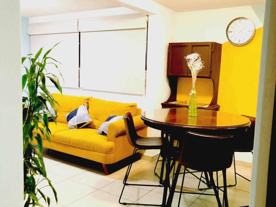 sala de estar con sofá amarillo y mesa en Tu refugio en CDMX cerca del Foro Sol y del AICM, en Ciudad de México
