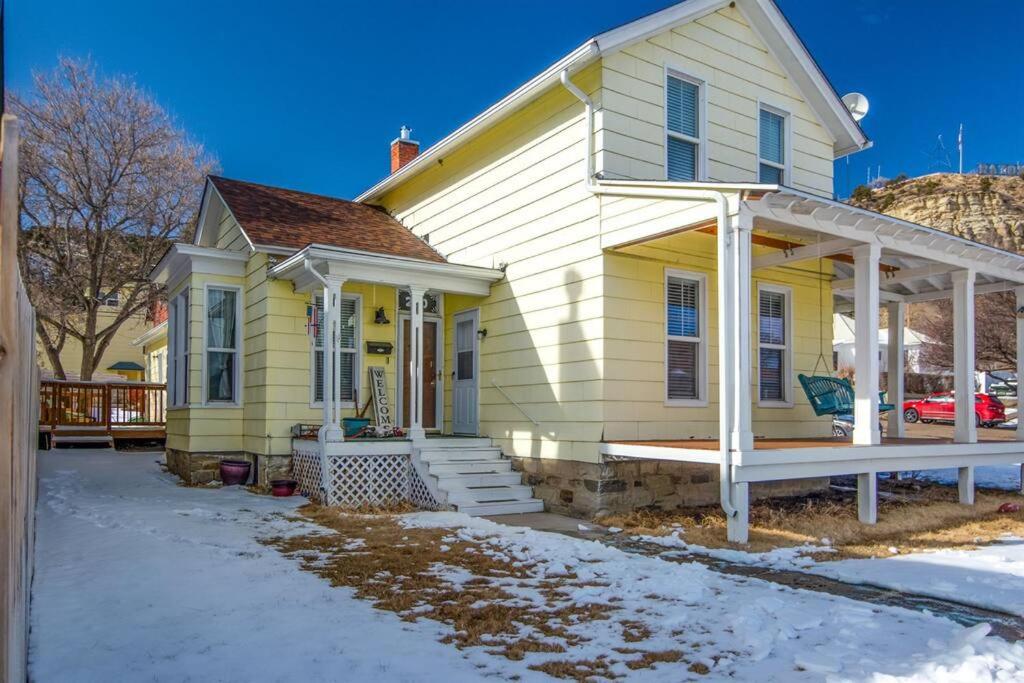 żółty dom z werandą w śniegu w obiekcie Charming, Historic Pet & Family Friendly Home! w mieście Raton
