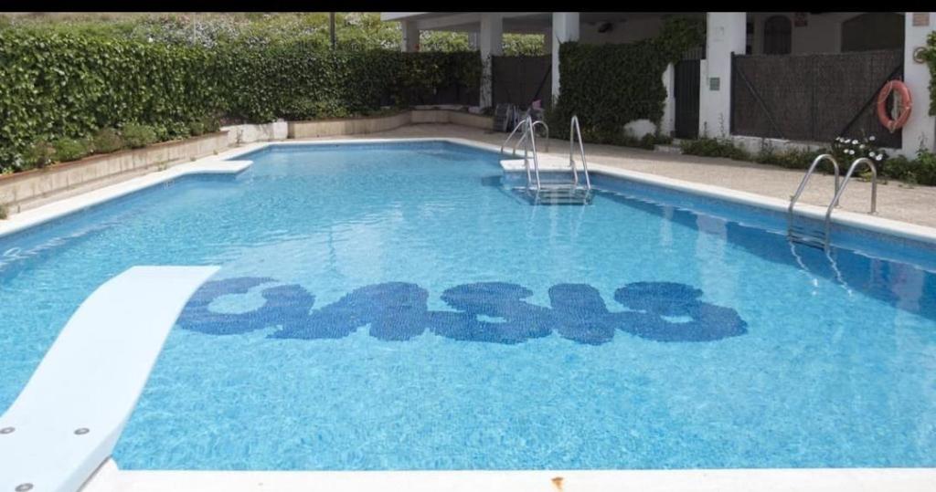 a swimming pool with the word care written on it at Sitges Oasis in Sitges