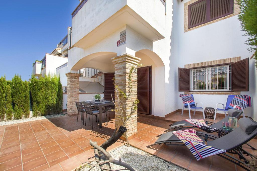 a house with a patio with a table and chairs at Azul Beach by La Mata Beach in Torrevieja
